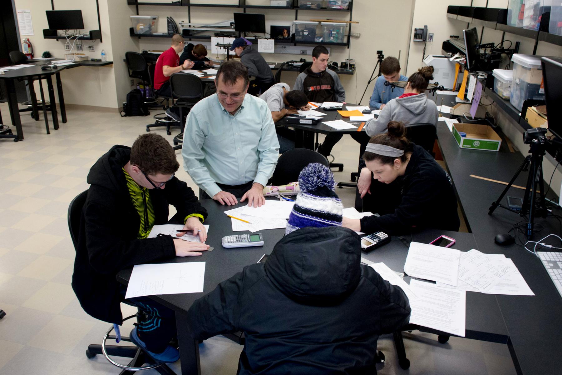 Professor with students in physics lab